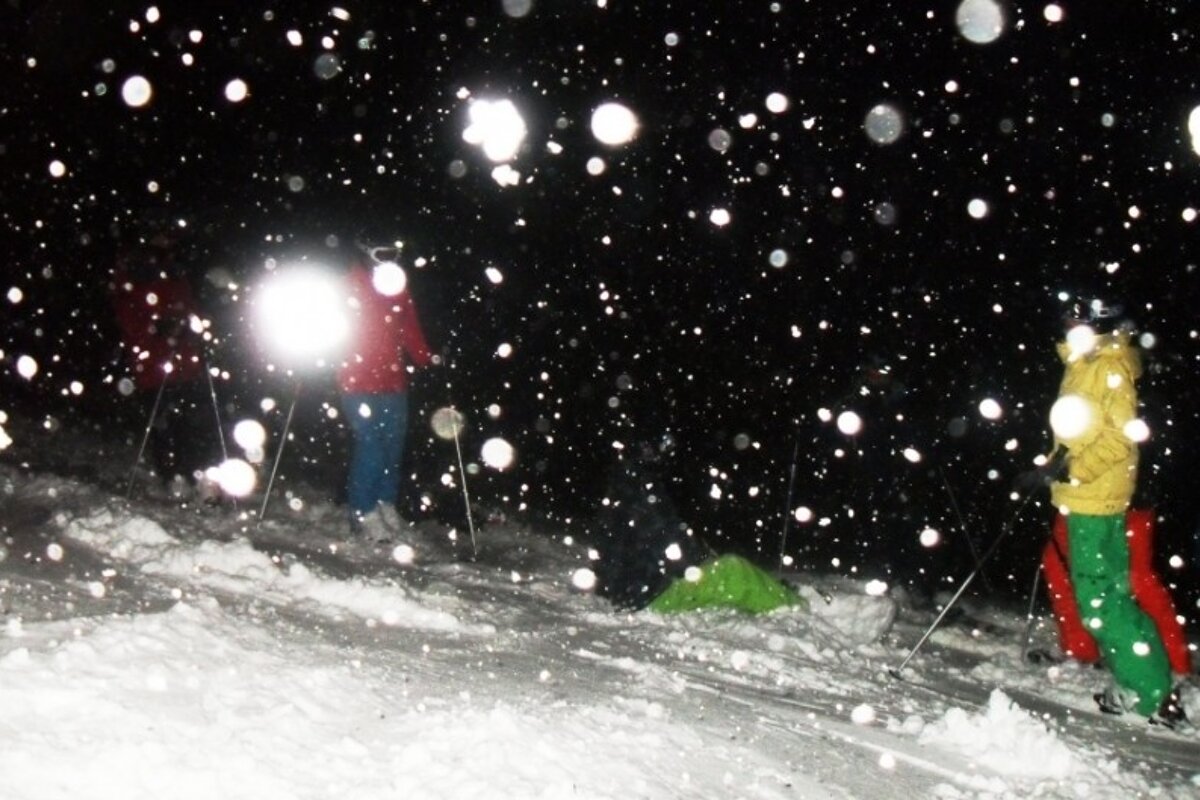 an image of skiers at night