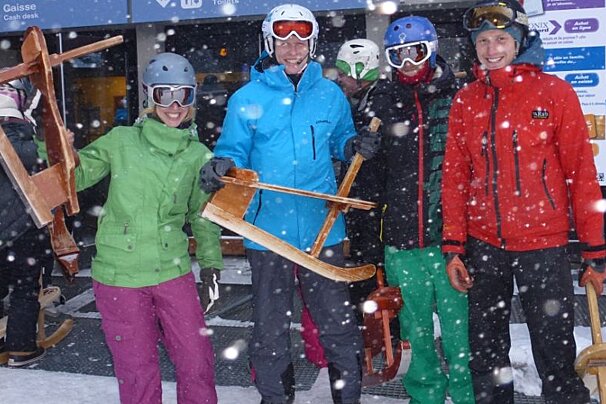 a picture of a groupe of people with weird wooden sledges