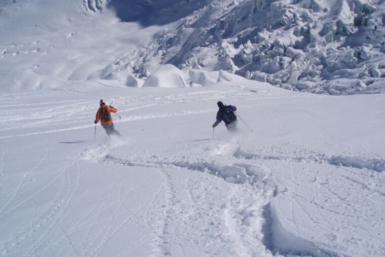 a picture of a couple of skiers in deep snow