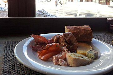 A plate of food sits on a table in front of a window