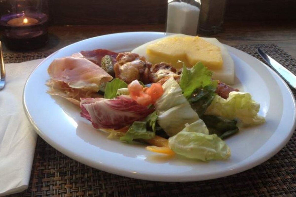A white plate topped with a salad and a slice of pineapple