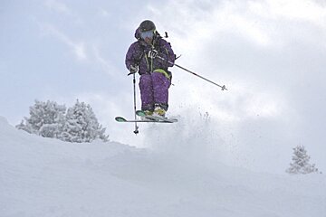an image of a skier jumping in powder