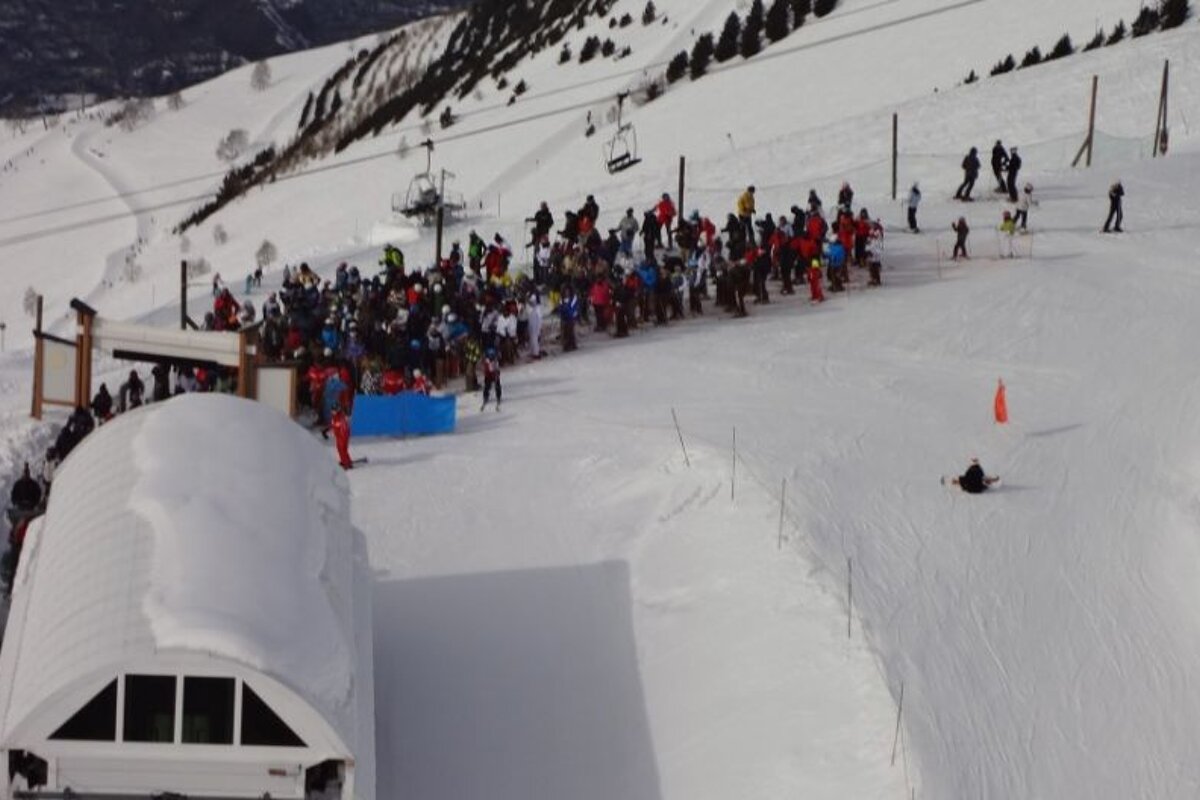 A large group of people are gathered on a snowy mountain