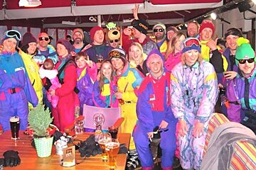 A group of people posing for a picture with one wearing an oakley hat