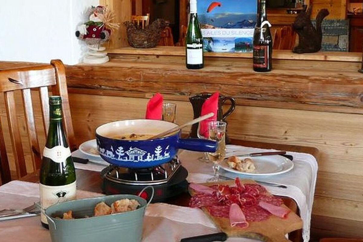 an image of a cheese fondue and charcuterie in an alpine restaurant in a ski resort