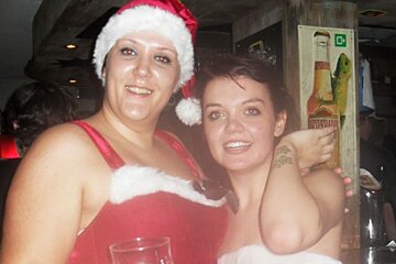 a picture of 2 girls dressed in santa costumes
