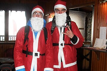 a picture of a couple of guys dressed as santa