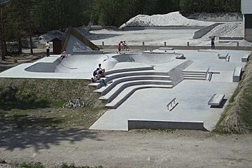 A group of people are sitting on the steps of a skate park