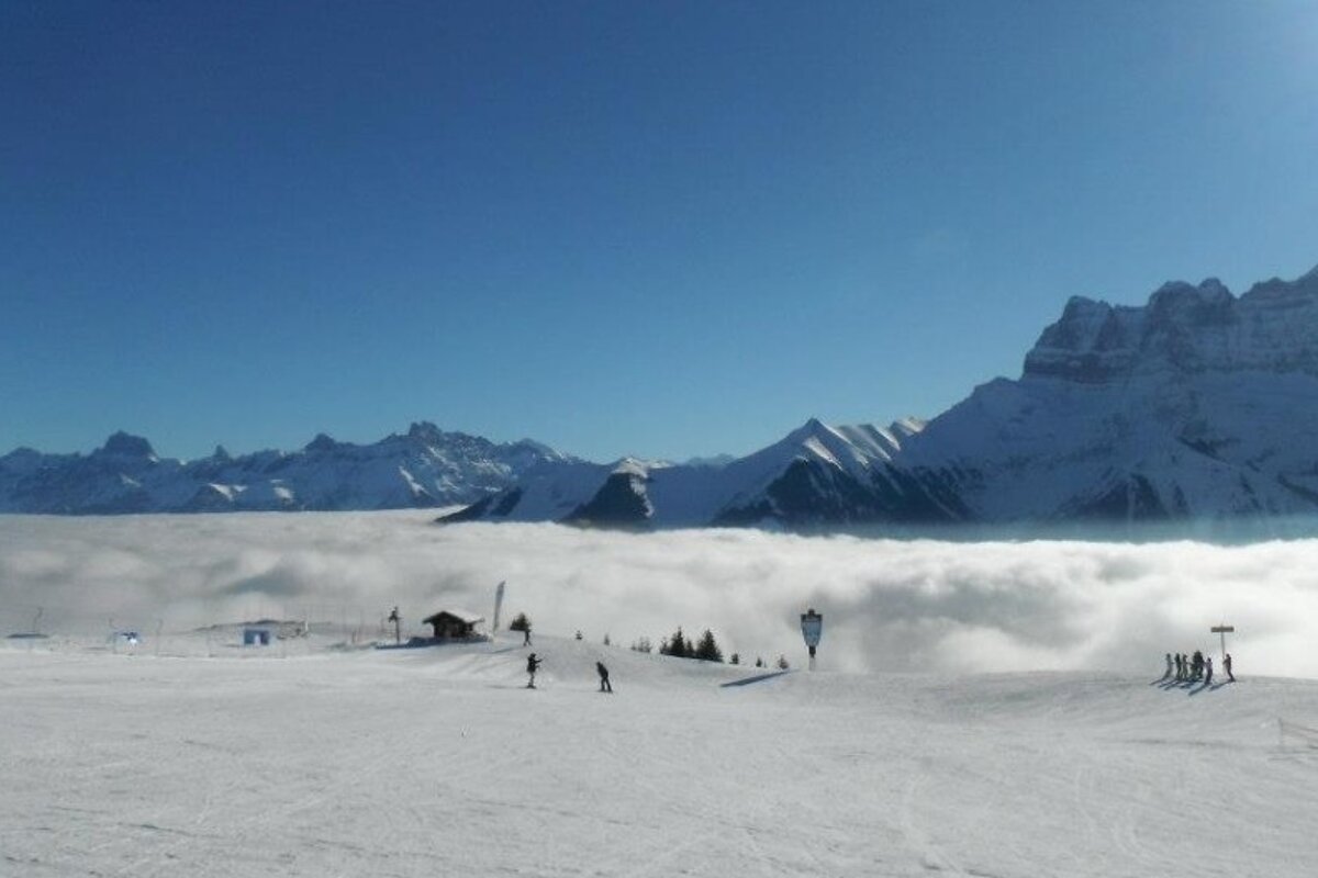 an image of ski pistes and cloud in the valley