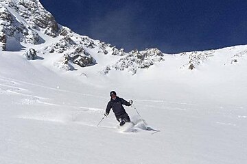 Man skiing powder blue skies