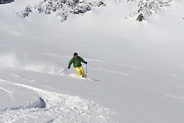 Man skiing powder blue skies