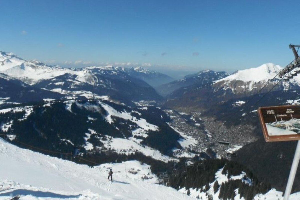 A ski lift is going up a snowy mountain