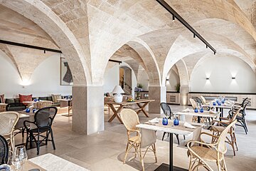 A restaurant with arched ceilings and tables and chairs