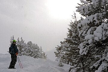 A person standing in the snow with skis and poles