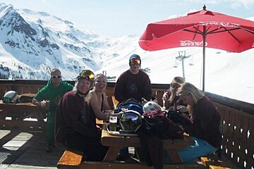 an image of people sunbathing on a terrace in a ski resort