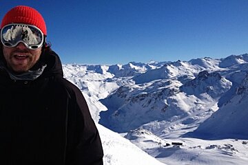 an image of a man on top of the mountains wearing goggles