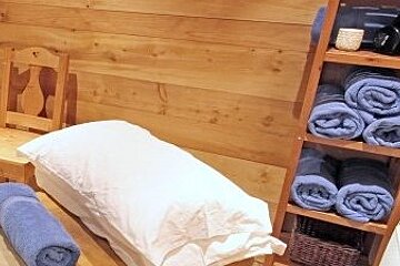 a picture of a massage table and shelves with towels in