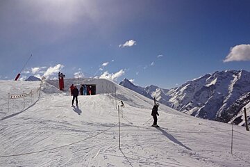 Skiers on a snowy slope with a sign that says ' altitude ' on it