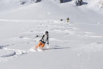 Man skiing powder blue skies