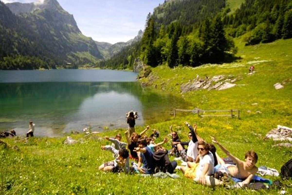 a picture of a group of kids lying by a lake in verbier
