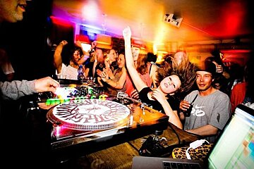 An image of a DJ playing to a crowd of dancing people at an apres-ski bar in Chamonix Mont Blanc