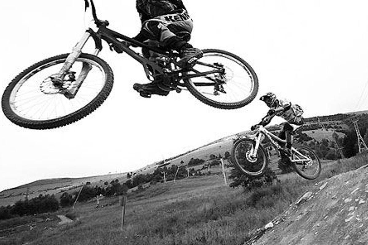 a picture of a couple of mountain bikers in 2 alpes in black and white
