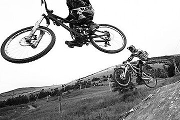 a picture of a couple of mountain bikers in 2 alpes in black and white