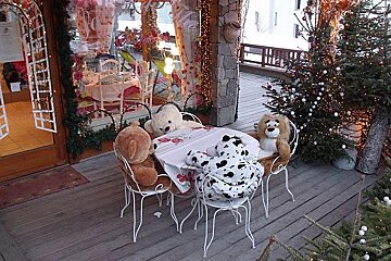 A table with stuffed animals on it and a christmas tree in the background