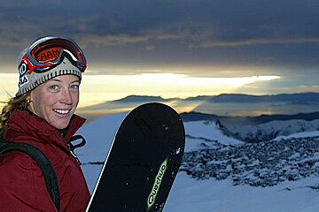 A woman holding a snowboard that says quechua on it