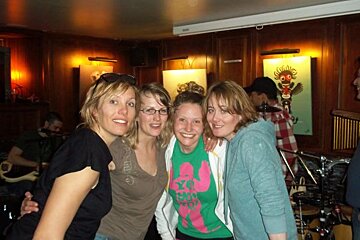 Four women posing for a picture with one wearing a shirt that says xoxo