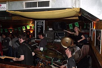 A man playing drums in front of a sign that says hot or smoke air duct
