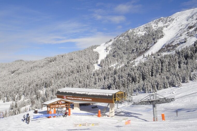 A snowy mountain with a ski lift in the foreground