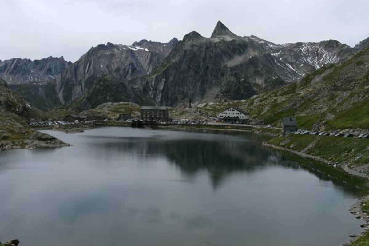 A lake with mountains in the background and a building in the foreground