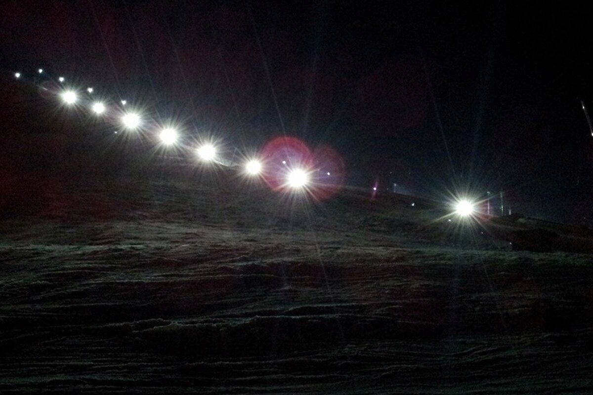 Night skiing piste lit up with flood lights