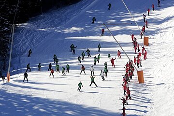 A group of people skiing down a snow covered slope