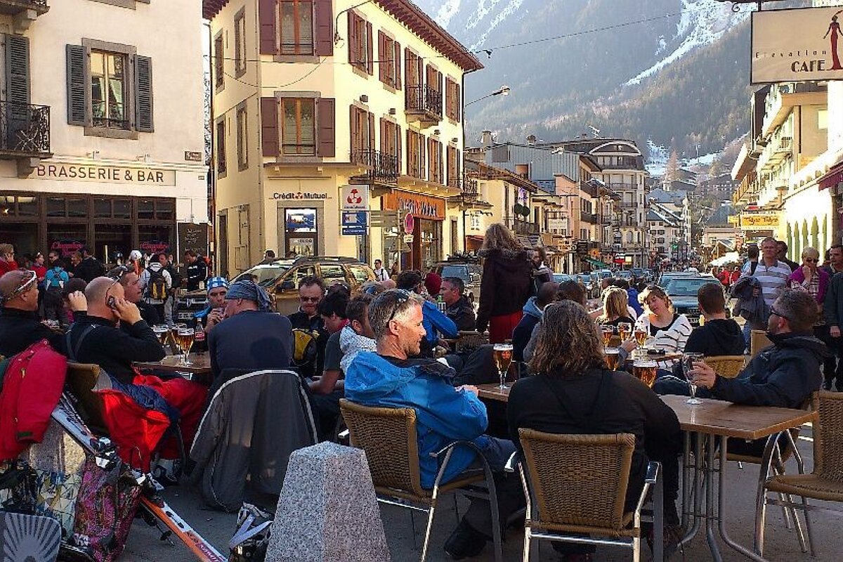 An image of skiers and snowboarders having apres-ski drinks outside bars in Chamonix Mont Blanc
