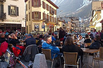 An image of skiers and snowboarders having apres-ski drinks outside bars in Chamonix Mont Blanc
