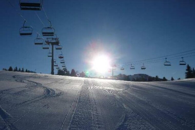 an image of a sunny ski piste in morzine and a chair lift