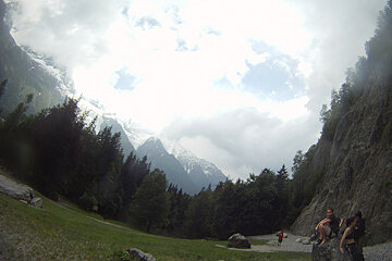 A group of people sitting on a rock with mountains in the background