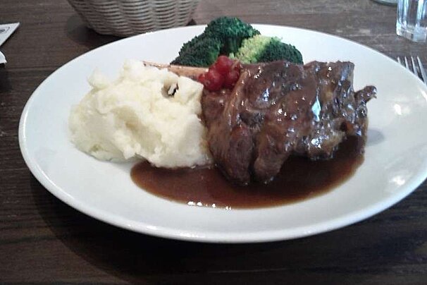 an image of a plate of food - lamb shank with mashed potatoes and broccoli