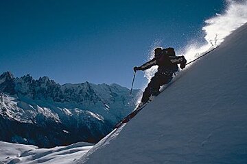 A person is skiing down a snow covered mountain