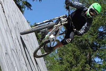 A person wearing a helmet and goggles is doing a trick on a bike