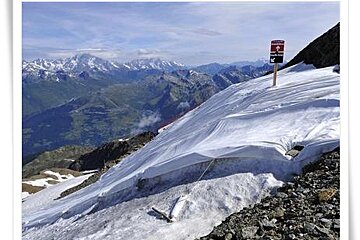 A snowy mountain with a sign on the side of it