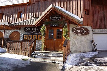 The entrance to smithy 's tavern is covered in snow