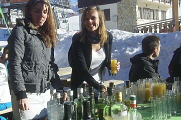 two girls serving drinks outside at the Grotte du Yeti in Alpe d'Huez