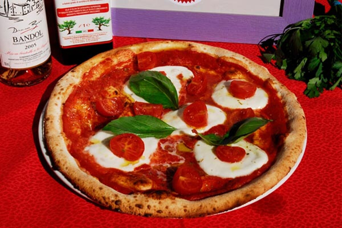 A pizza next to a bottle of bandol wine