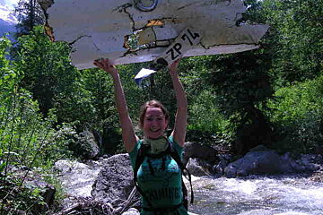 A woman holding up a piece of paper that says zp74