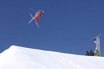 freeride skier mid-air on a jump