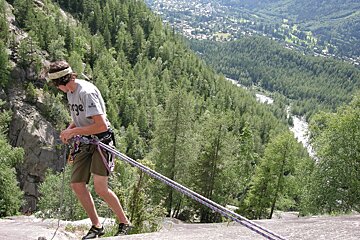 A man wearing a grey shirt with the word force on it climbs a mountain