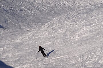 A person skiing down a snow covered slope